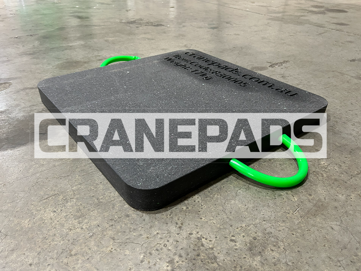Black crane pad with green handles on a concrete floor, branded 'CranePads'.