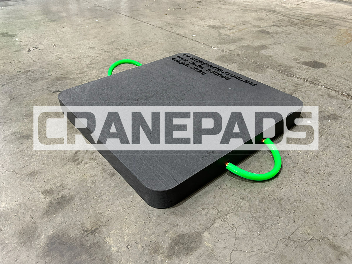 Black crane pad with green handles on a concrete floor, featuring the 'CRANEPADS' brand.
