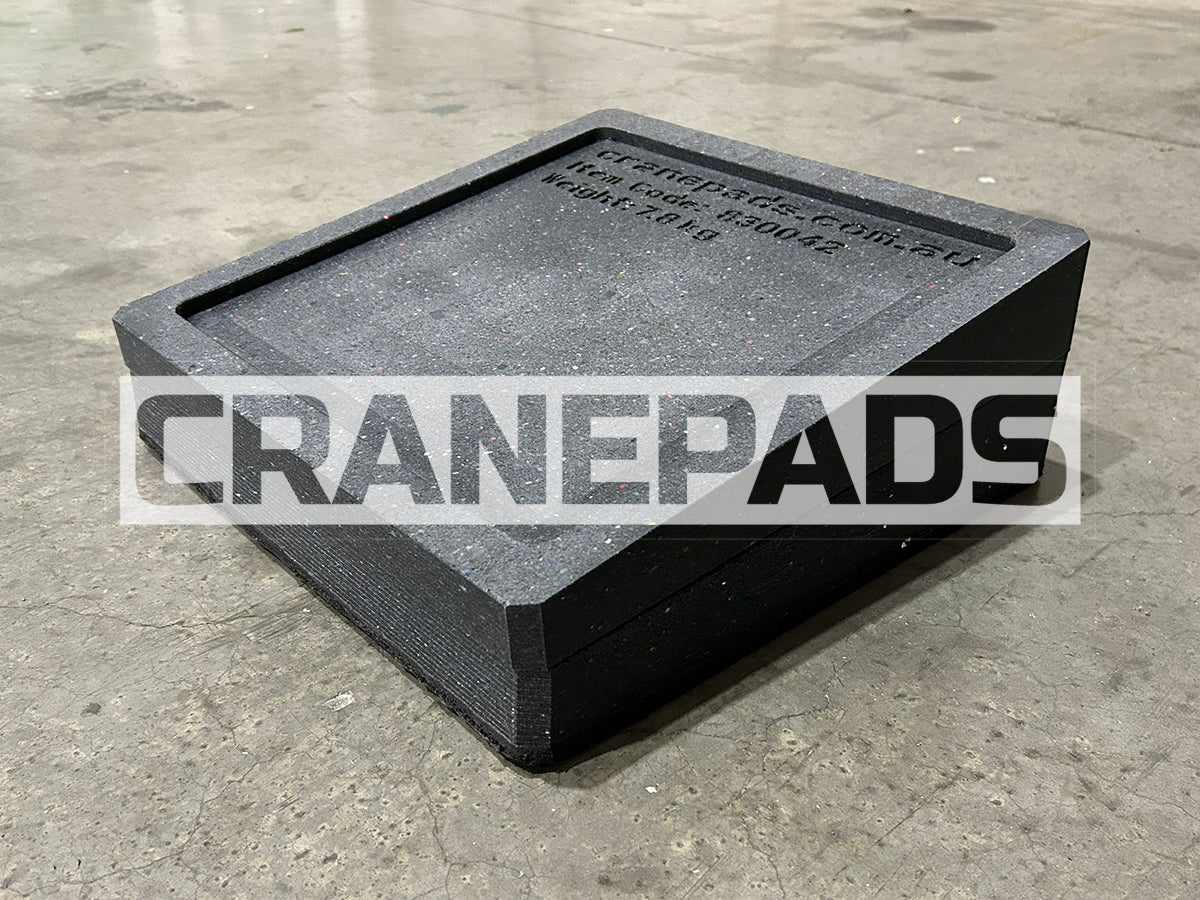 Black crane pad on a concrete floor with 'CRANEPADS' branding.