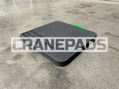 Black crane pad on a concrete floor with 'CRANEPADS' branding.