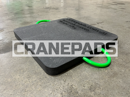Black crane pad with green handles on a concrete floor, branded 'CranePads'.
