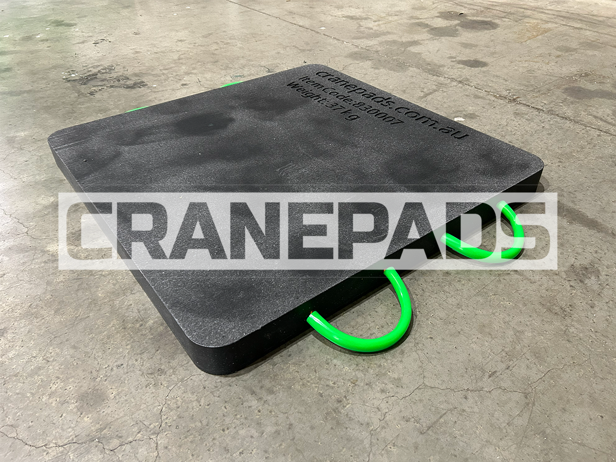 Black crane pad with green handles on a concrete floor, featuring 'CRANEPADS' branding.