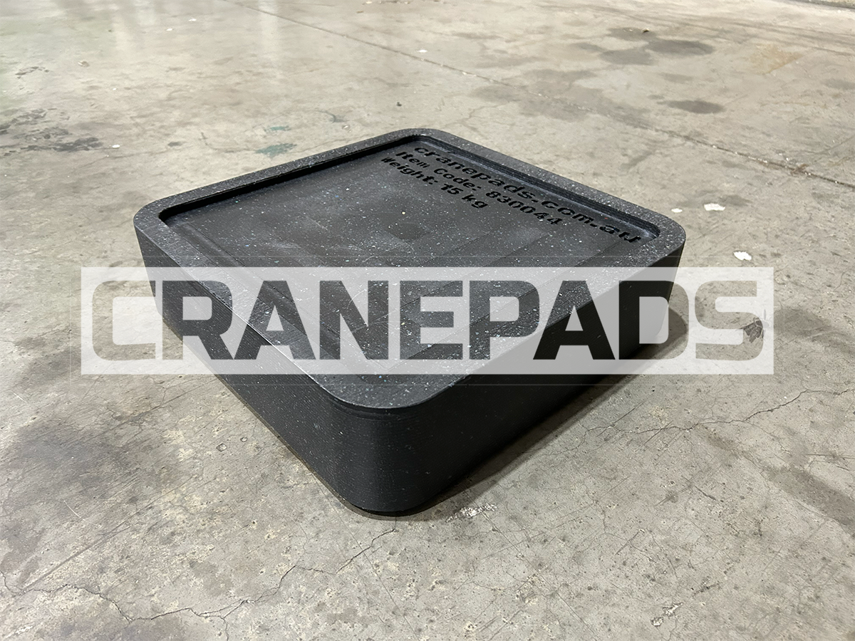 Black crane pad on a concrete floor with 'CRANEPADS' branding.
