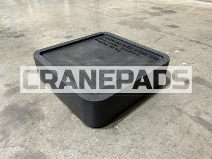 Black crane pad on a concrete floor with 'CRANEPADS' branding.